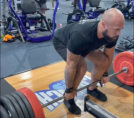 Dr. Junior setting up for a barbell deadlift at the gym.